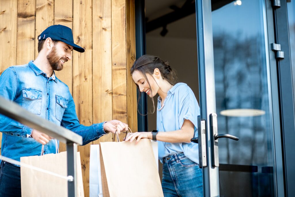 Delivery man bringing goods home for a woman client